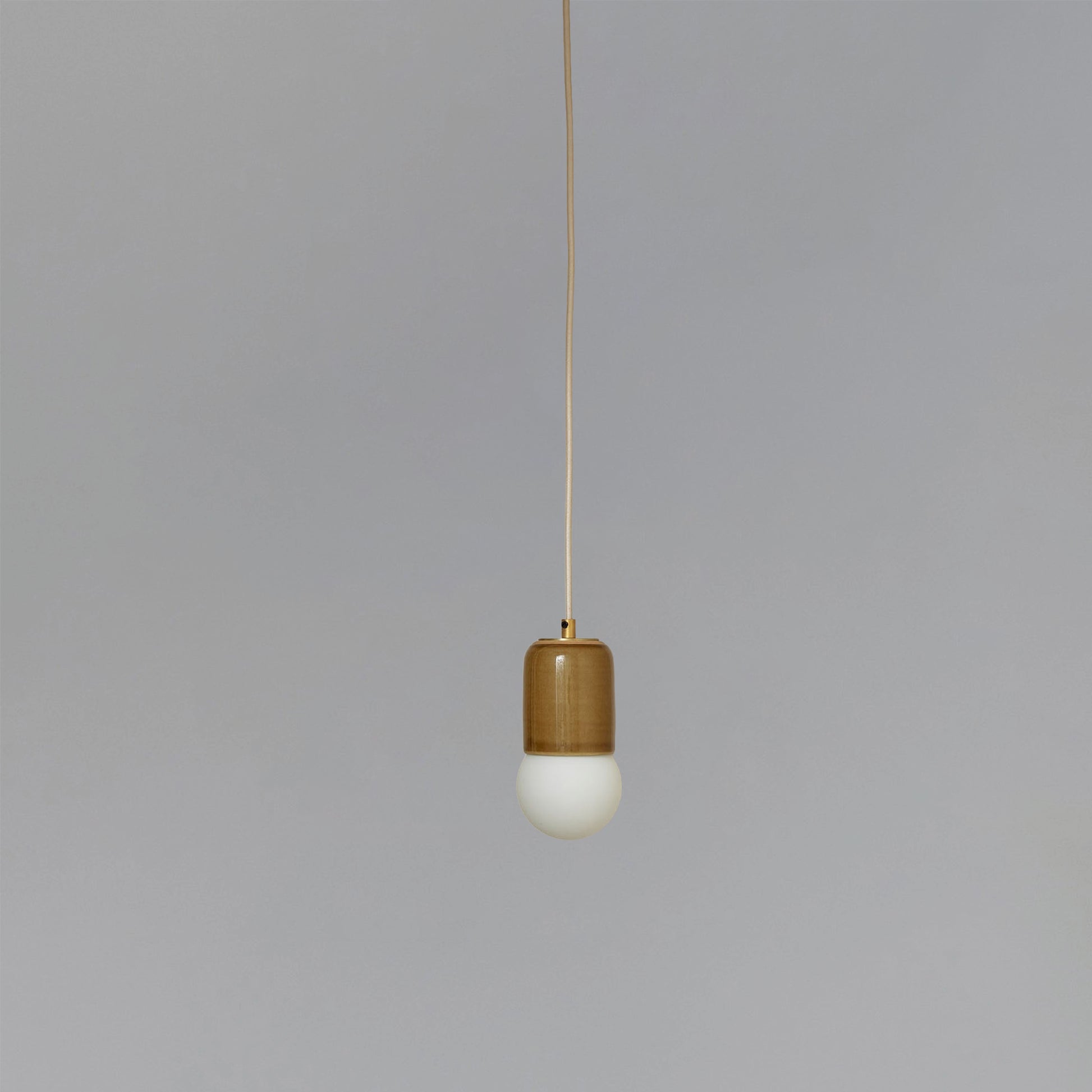 Marz Designs Terra 1 Pendant in Chartreuse ceramic and Brushed Brass hardware with fabric flex cord and frosted glass.