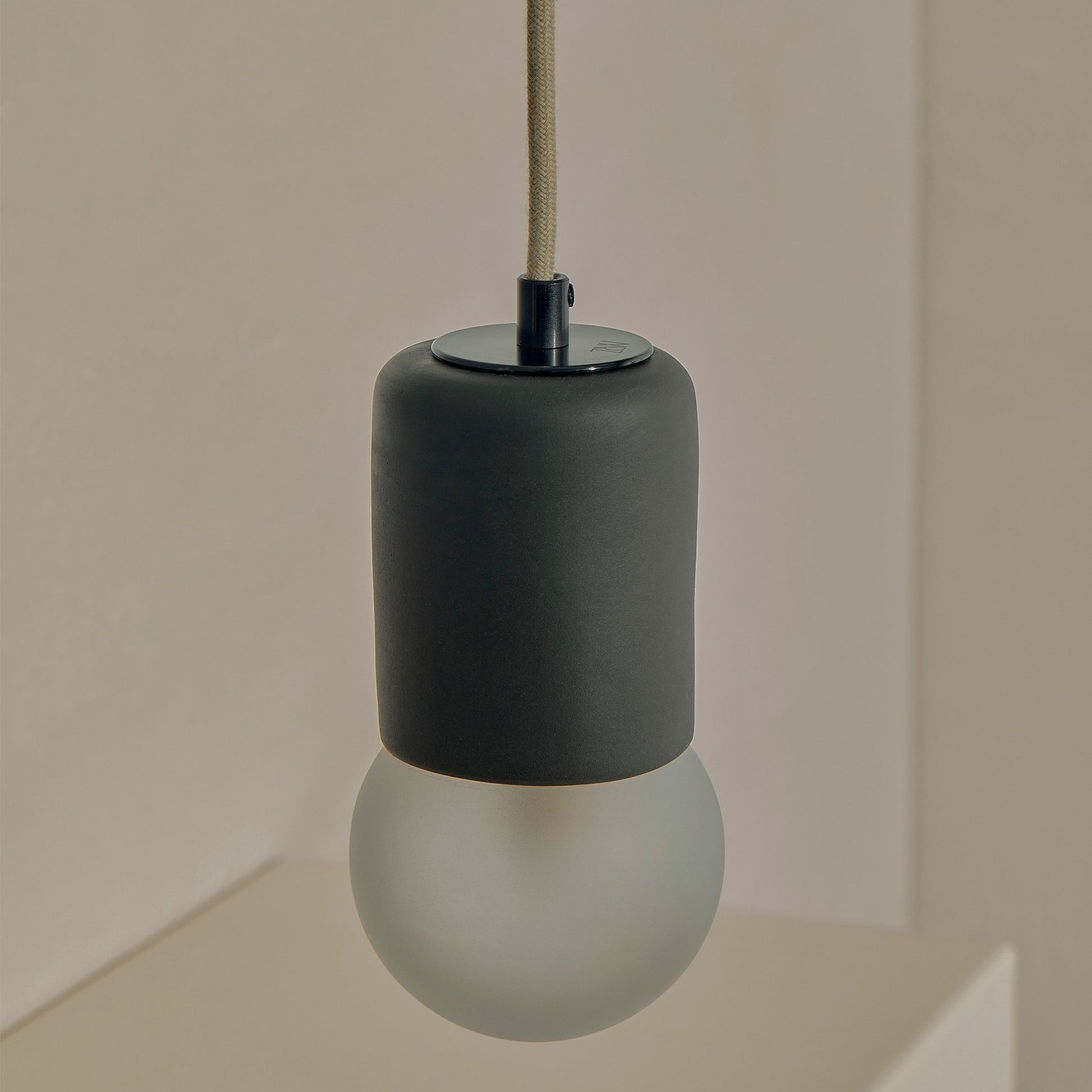 Marz Designs Terra 1 Pendant in matte black ceramic finish with fabric flex cord and frosted glass globe.